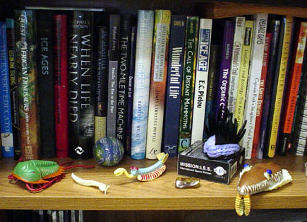 Bookshelf with some print resources and toy trilobites