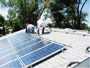 Crews installing solar thermal collectors on the roof of a zero-energy house